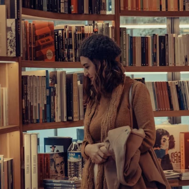 A woman looking at a bookshelf