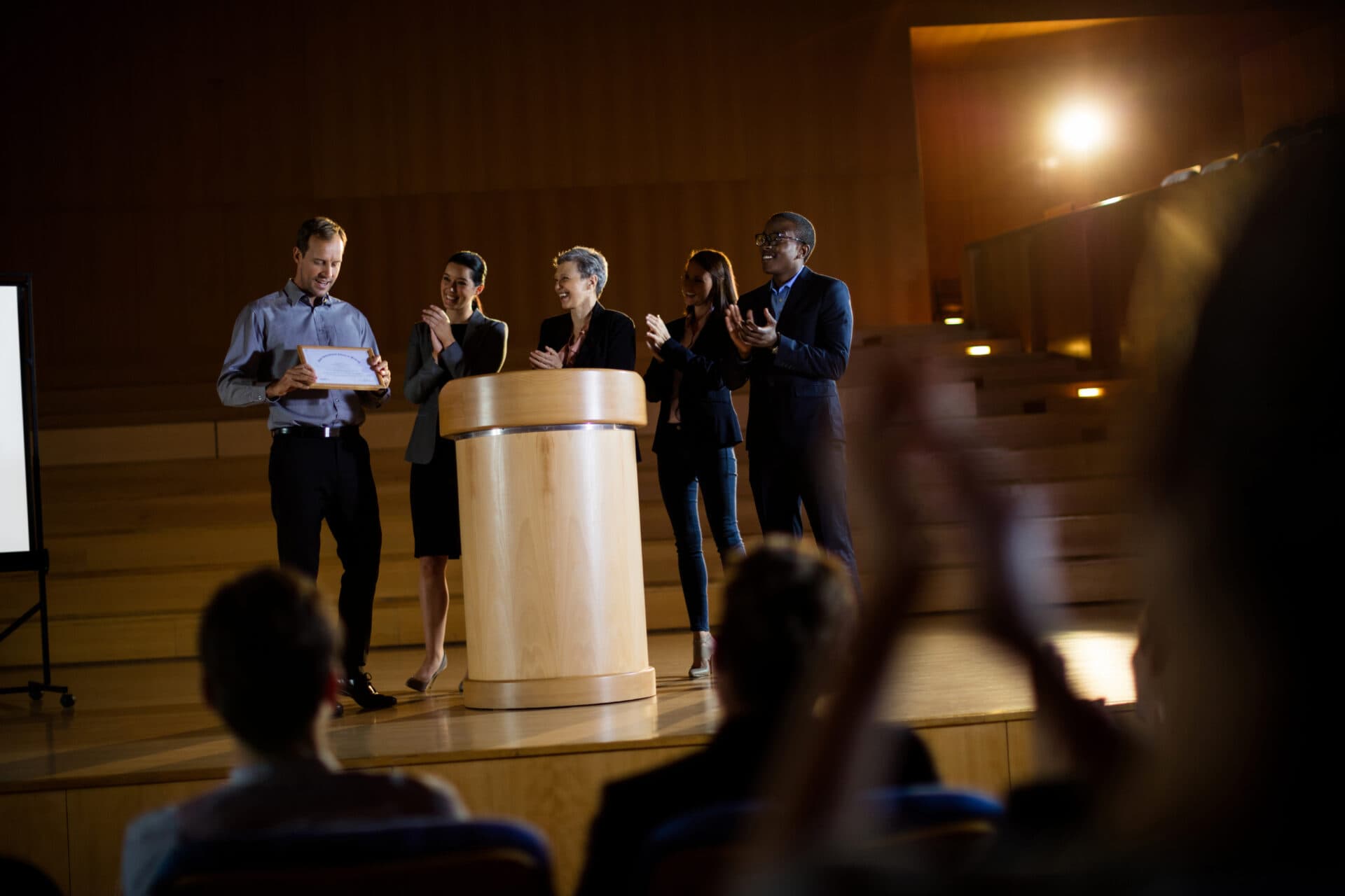 Male business executive receiving award at conference center